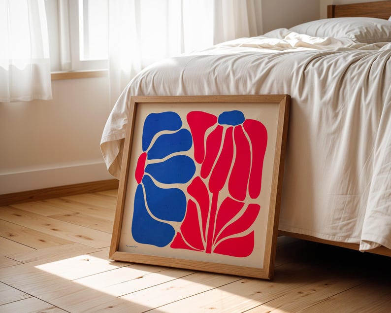 May include: A framed print of an abstract floral design with blue and red shapes on a white background.