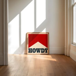 May include: A framed print with a red and white graphic of a cigarette with the word "HOWDY" in black lettering.