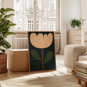 May include: A framed print of a stylized flower with a cream-colored blossom and green leaves on a dark blue background.
