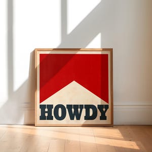 May include: A framed print with a red and white geometric design and the word "HOWDY" in black lettering.