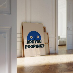 Op de afbeelding: Een witte poster met een blauw cartoon gezicht en de tekst "ARE YOU POOPING?" in zwart gedrukt.