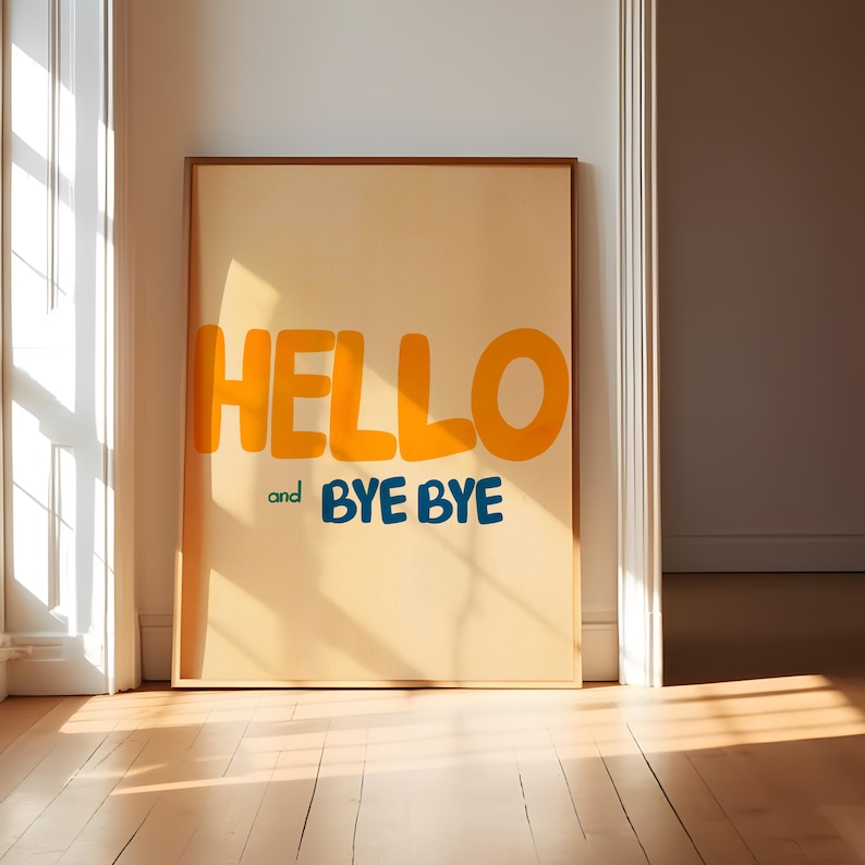 May include: A framed print with a yellow background and the words "HELLO" and "and BYE BYE" in a bold, playful font.