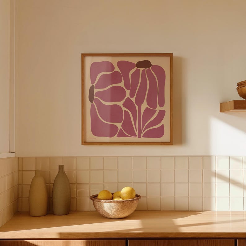 Pu&ograve; includere: Una stampa incorniciata di un design floreale astratto rosa con una cornice in legno. La stampa &egrave; appesa a una parete piastrellata bianca sopra un bancone in legno.
