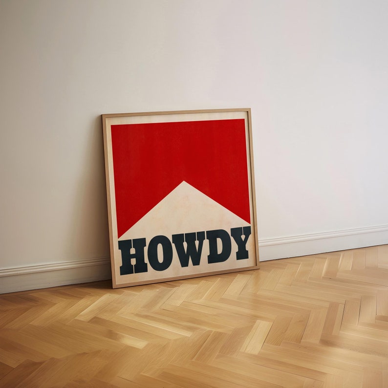 May include: A framed print with a red and white geometric design and the word "HOWDY" in black lettering.