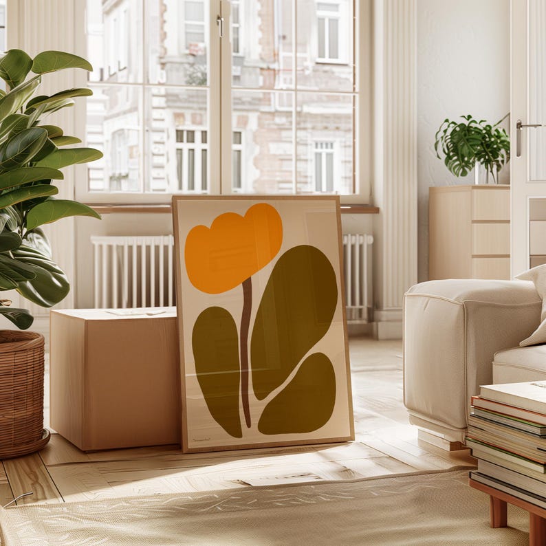 Peut inclure: Une impression abstraite encadr&eacute;e d'une fleur stylis&eacute;e avec un centre jaune et des feuilles vertes. L'impression est accroch&eacute;e &agrave; un mur dans un salon.
