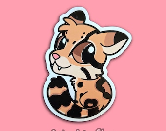 May include: A sticker featuring a cartoon ocelot with a tan and black spotted coat, large brown eyes, and a pink nose. The sticker has a white border and the text "GolondrinaShop" at the bottom, set against a pink background.