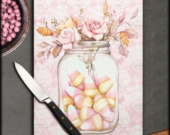 Pode incluir: Um frasco de vidro cheio de milho doce rosa e amarelo, rodeado por um buquê de rosas rosa e amarelas com folhas verdes. O frasco e as flores estão sobre um fundo rosa com um padrão de renda branca.