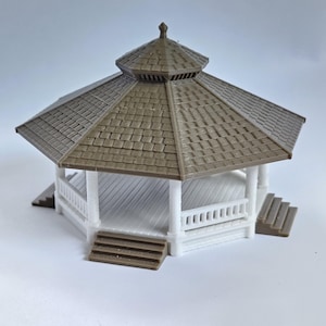 May include: A white and brown wooden gazebo with a shingled roof and a white railing. The gazebo has steps on two sides.