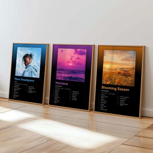 May include: Three framed album art prints. The first features a person with dreadlocks, the second a sunset over water, and the third a car in a field. Each print has a black background with white text listing the album's songs and artist.