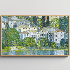 May include: A painting of a village with white buildings and green trees along a blue lake. The buildings are clustered together and have a variety of shapes and sizes. The trees are lush and green, and the lake is calm and serene.