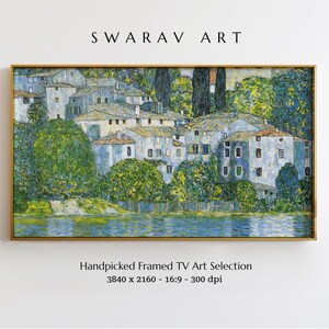 May include: A framed painting of a village scene with white buildings and green trees. The buildings are clustered together on a small island in a lake. The water is a light blue color and the sky is a light gray color. The painting is in a gold frame.