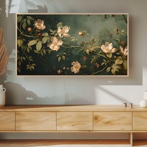 May include: A framed painting of white flowers with green leaves on a dark green background.
