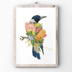 May include: A framed art print depicting a magpie with a floral arrangement. The bird has a black head, white neck, and blue wings. The flowers include pink protea, yellow banksia, and other blooms. The artwork is set against a white background.