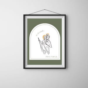 May include: A framed print with a green background and a white arch. Inside the arch is a black and white line drawing of Saint Christopher carrying a child on his shoulders. The text "St. Christopher" and "Pray for Us" are written in black.