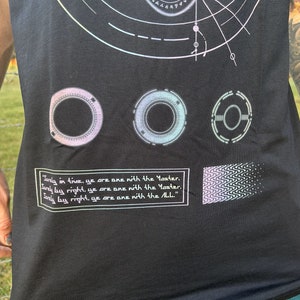 May include: Black tank top with a graphic design featuring three circular symbols, a geometric pattern, and the text "Only in time, ye are one with the Master. Only by right, ye are one with the Master. Only by right, ye are one with the All."