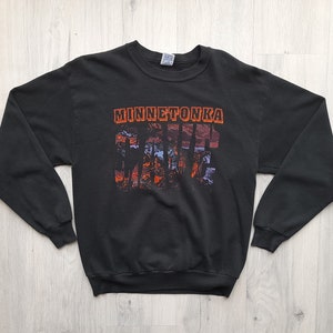 May include: Black sweatshirt with a graphic print of a sunset scene with the text "Minnetonka" and "Cabin Fever" in orange.
