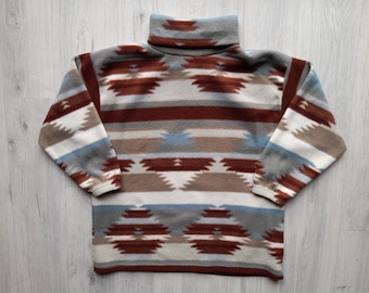 May include: A brown, white, and blue patterned turtleneck sweater with a geometric design.