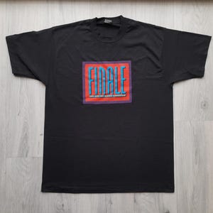 May include: Black t-shirt with a red and blue graphic that says "FINALE" and "You Can't Go Home Again Without It".