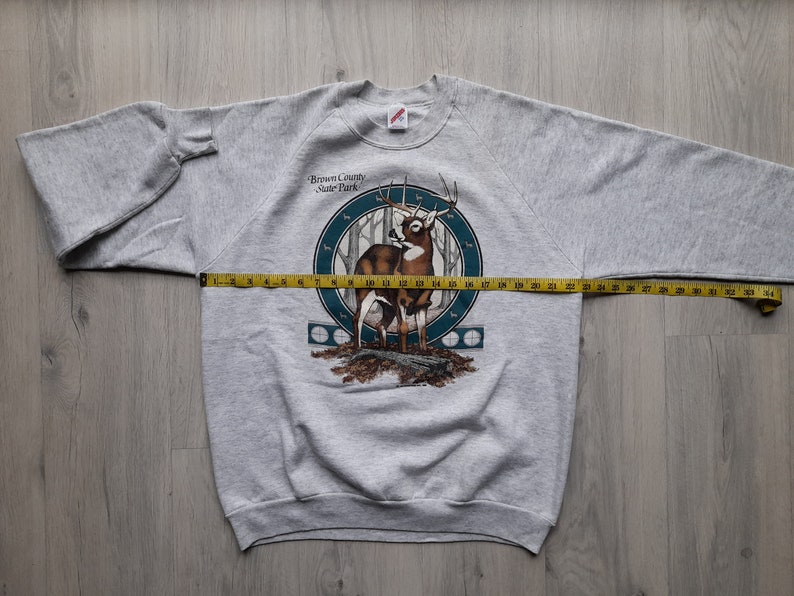 May include: Gray sweatshirt with a print of a deer in a forest scene. The text "Brown County State Park" is printed on the sweatshirt.