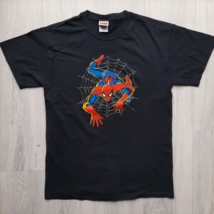 Pu&ograve; includere: T-shirt nero con grafica di Spider-Man. Il design mostra il supereroe nella sua tuta rossa e blu, con un contorno giallo, su una ragnatela bianca. La t-shirt &egrave; realizzata in materiale morbido.