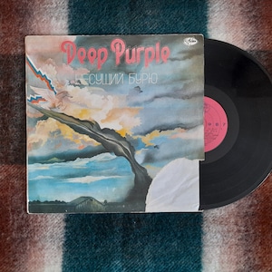 May include: A vinyl record album cover featuring a painting of a dark, swirling cloud against a blue sky. The album is titled "Deep Purple" with the text "Несущий Бурю" below the title.