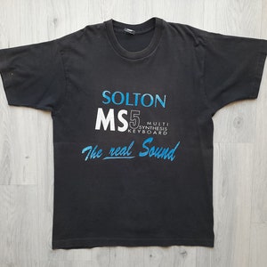 May include: Black t-shirt with a white and blue graphic that reads "Solton MS5 Multi Synthesis Keyboard The real Sound".