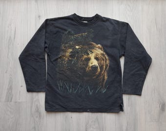 May include: Black long-sleeved sweatshirt with a graphic print of a brown bear in a forest setting.