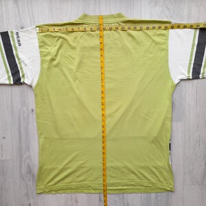 May include: A lime green t-shirt with white and black striped sleeves. The shirt has the word "WEAR" printed on the left sleeve.