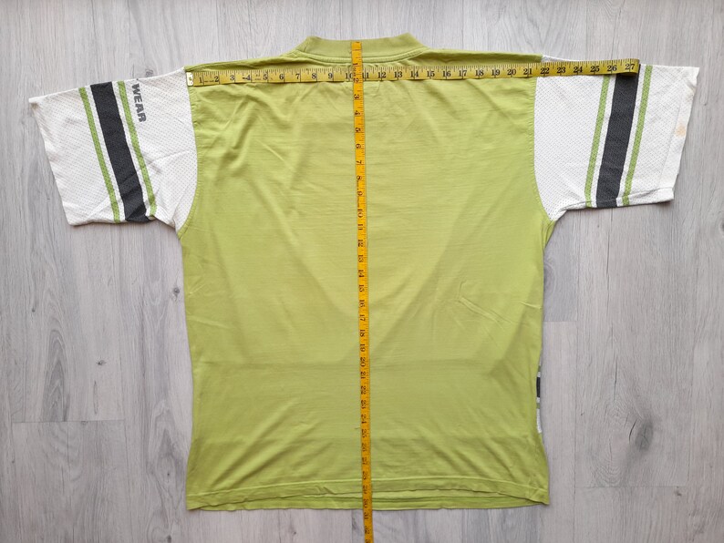 May include: A lime green t-shirt with white and black striped sleeves. The shirt has the word "WEAR" printed on the left sleeve.