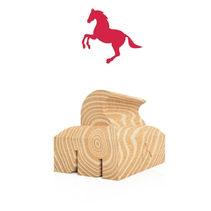 Puede incluir: Un sello de madera con un patrón detallado de veta de madera. El sello tiene forma de cabeza y cuello de caballo, con un diseño en relieve. El sello está sobre una superficie blanca.