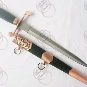May include: A silver dagger with a black handle and a copper-coloured scabbard with an anchor design. The scabbard has a copper-coloured tip and a copper-coloured ring.