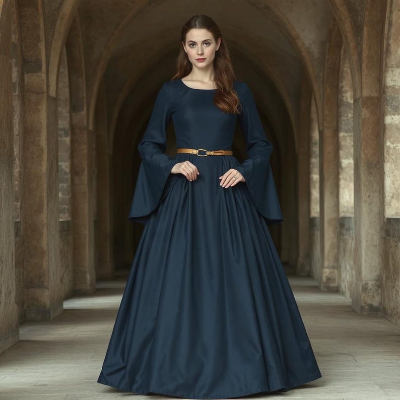 May include: A woman wearing a long, dark blue dress with a gold belt. The dress has long sleeves with bell-shaped cuffs. She is standing in a hallway with arched doorways.