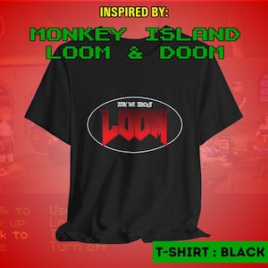 Könnte beinhalten: Schwarzes T-Shirt mit dem Text "ASK ME ABOUT LOOM" in roter, stilisierter Schrift in einem weißen Oval. Das Shirt zeigt auch den Text "INSPIRED BY: MONKEY ISLAND LOOM & DOOM" in Grün. Auf der Unterseite des Shirts steht "T-SHIRT: BLACK".