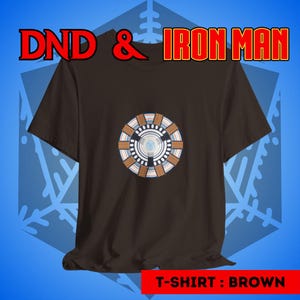 Puede incluir: Una camiseta marr&oacute;n con un gr&aacute;fico del reactor Arc de Iron Man en la parte delantera. El texto "DND & IRON MAN" est&aacute; en la parte superior de la imagen. El texto "T-SHIRT: BROWN" est&aacute; en la parte inferior de la imagen.