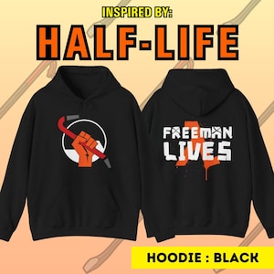 Puede incluir: Sudadera con capucha negra con un gráfico de palanca y puño en la parte delantera y el texto "FREEMAN LIVES" en la parte posterior. Inspirado en el videojuego Half-Life.
