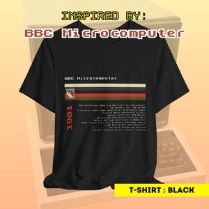 Pode incluir: Camiseta preta com um design gráfico branco com o texto "BBC Microcomputer" e as especificações técnicas do BBC Microcomputer, lançado em 1981. O texto está em uma fonte retro pixelada.