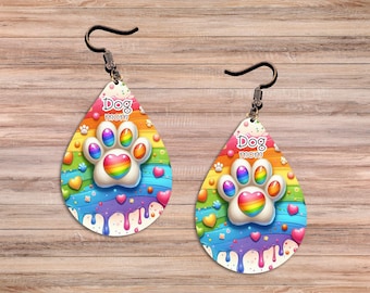 Könnte beinhalten: Regenbogenfarbene Hängeohrringe mit einem Pfotenabdruck und einem Herz in der Mitte. Die Ohrringe sind tropfenförmig und tragen die Aufschrift "Dog Mom".
