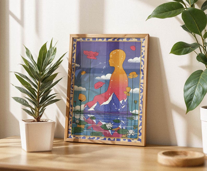 May include: A framed print of a colorful abstract illustration depicting a person sitting in a lotus position with a mountain range behind them. The background is a blue sky with clouds and flowers.