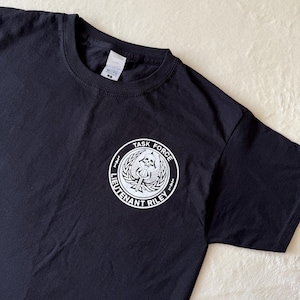 May include: Black t-shirt with a white graphic of a skull with wings and the text "Task Force Lieutenant Riley".