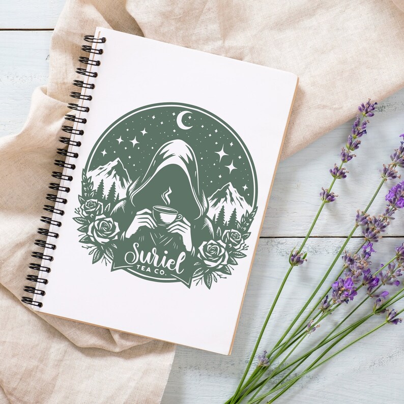 K&ouml;nnte beinhalten: Eine gr&uuml;ne und wei&szlig;e Illustration einer Kapuzenfigur, die eine Tasse Tee h&auml;lt. Die Illustration ist von einem Kreis mit Sternen, einer Mondsichel und Bergen umgeben. Der Text "Suriel Tea Co." befindet sich unter der Figur.