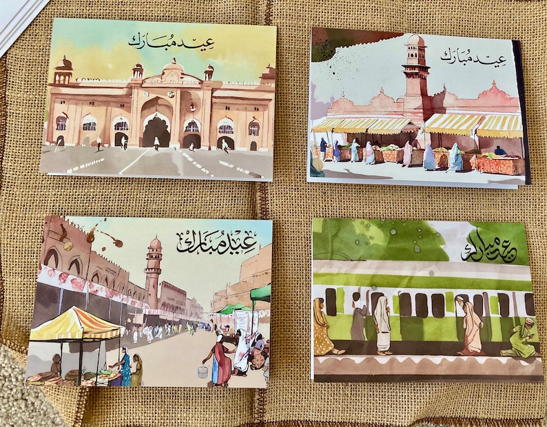 K&ouml;nnte beinhalten: Vier Aquarell-Gru&szlig;karten mit architektonischen Szenen und arabischer Kalligraphie. Die Karten zeigen Geb&auml;ude, M&auml;rkte und einen Bahnhof mit Figuren von Menschen. Die Karten sind auf einer Jutefl&auml;che angeordnet.