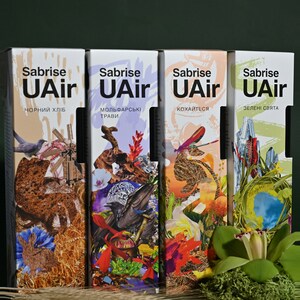 May include: Four colorful boxes with the text "Sabrise UAir" and different Ukrainian phrases. The boxes feature a variety of images, including a raven, a windmill, a field of wheat, and a green orchid.