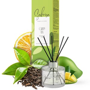 May include: A clear glass Sabrise aromatic diffuser with black reeds, labelled "Green Tea." The product is surrounded by green tea leaves, a lemon slice, and a mango. The packaging is a green box with the Sabrise logo.