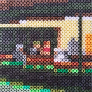 May include: A close-up of a pixel art image made with colorful beads. The image depicts a scene with a brown building, a red roof, and a white fence. The beads are arranged in a grid pattern, creating a mosaic effect.