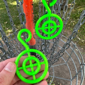 May include: Two bright green disc golf target practice rings with a hook on top. The rings have a bullseye design with concentric circles.