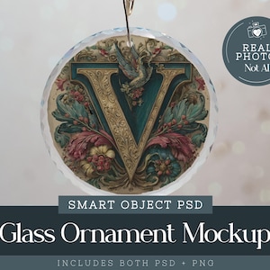 May include: A circular glass ornament featuring the letter "V" in teal and gold, with floral and bird designs. It hangs from a gold hook. The text "REAL PHOTO Not AI" is in a circle. The text "SMART OBJECT PSD" and "Glass Ornament Mockup" are also visible.