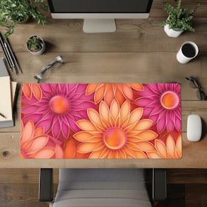 Op de afbeelding: Een bloemenbureau-onderlegger met een herhalend patroon van grote, gestileerde bloemen in roze en oranje tinten. De bloemen hebben een gradiënteffect, met donkerdere centra en lichtere bloemblaadjes. De mat is rechthoekig.