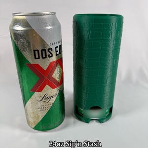 May include: A 24 fl oz Dos Equis Lager beer can next to a green, textured, cylindrical container. The can is silver, green, and red. The text "24oz Sip'n Stash" is at the bottom.