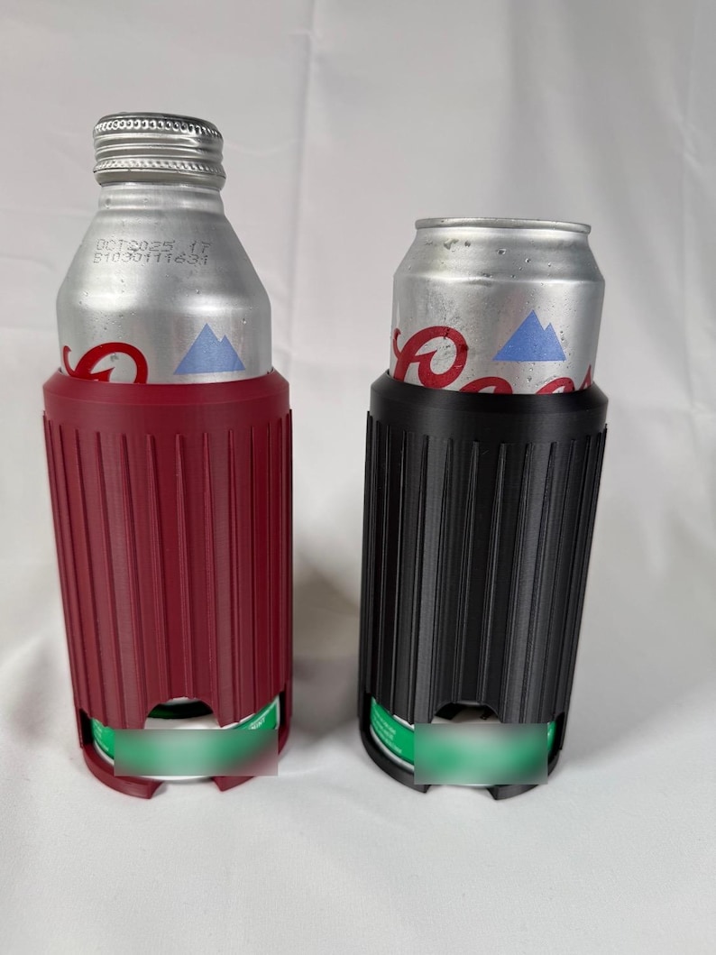 May include: Two beverage insulators, one burgundy and one black, each holding a silver can. The insulators have a ribbed design and a cutout at the bottom. The cans have a blue mountain logo.