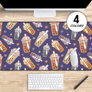 May include: A purple desk mat with a repeating pattern of colorful boba tea cups with straws and stars. The text "4 COLORS" is in the upper right corner of the mat.